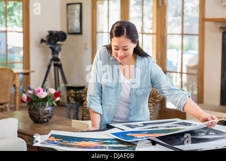 Mixed Race photographe examinant imprime Banque D'Images