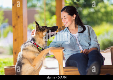 Mixed Race woman petting dog Banque D'Images