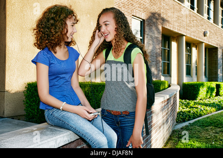 Mixed Race étudiants listening to headphones Banque D'Images