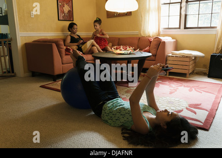 Mixed Race family relaxing in living room Banque D'Images