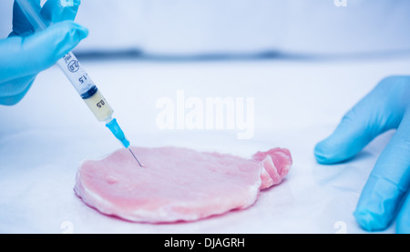 Close up de mains gantées, les chercheurs de la viande par injection Banque D'Images