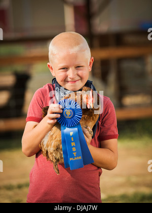 Young boy avec prize winning chicken on farm Banque D'Images