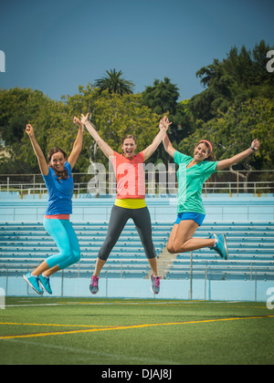 Les femmes de race blanche sauter de joie en terrain du stade Banque D'Images