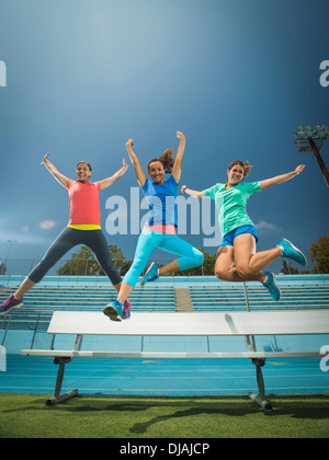 Les femmes de race blanche sauter de joie dans le stade Banque D'Images