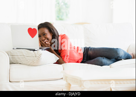 Black woman using laptop on sofa Banque D'Images