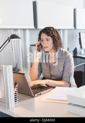 Hispanic businesswoman working in office Banque D'Images