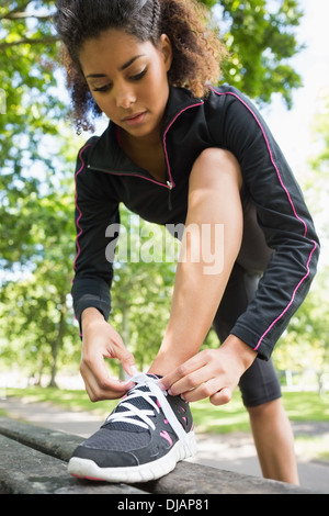 Jeune femme portant des chaussures de sport dans le parc Banque D'Images