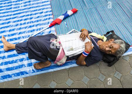 Bangkok, Thaïlande. 26 nov., 2013. Un des manifestants anti-gouvernement dort dans la cour au ministère des Finances à Bangkok. Les manifestants opposés au gouvernement du Premier Ministre thaïlandais Yingluck Shinawatra distribués par Bangkok cette semaine. Les manifestants ont pris le contrôle du ministère des Finances, ministère des Sports et du tourisme, ministère de l'intérieur et d'autres plus petits ministères. Les protestataires exigent la démission du Premier Ministre. Credit : ZUMA Press, Inc./Alamy Live News Banque D'Images