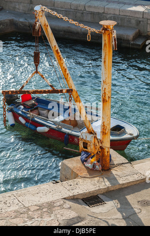 Vieux bateau de pêche et petit crane dans port de la ville de Petrovac, Monténégro Banque D'Images