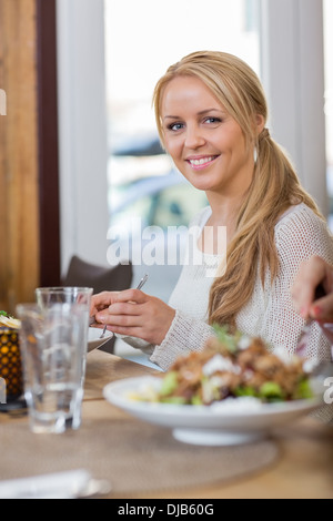 Jeune femme ayant l'alimentation au Coffeeshop Banque D'Images