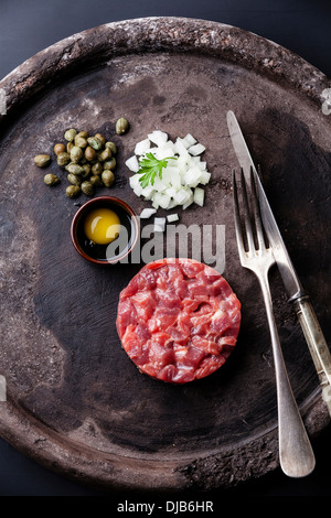 Tartare de boeuf aux câpres et oignons frais on black background Banque D'Images