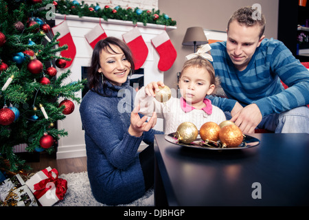 Jeune famille in front of Christmas Tree Banque D'Images