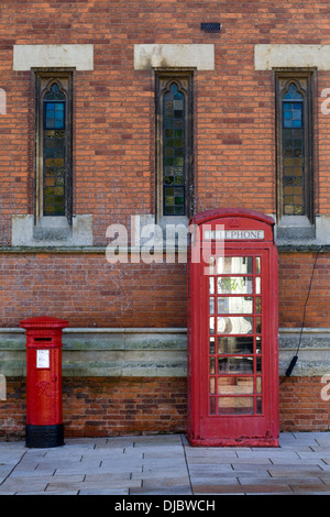 Boîte de téléphone rouge et Post Box contre un bâtiment Banque D'Images