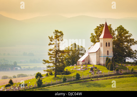 Belle petite église minuscule village en Slovaquie avec l'arrière-plan sur la montagne Banque D'Images