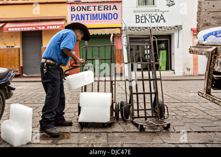 Une décharge d'Iceman de blocs de glace au marché de Benito Juarez à Oaxaca, au Mexique. Banque D'Images