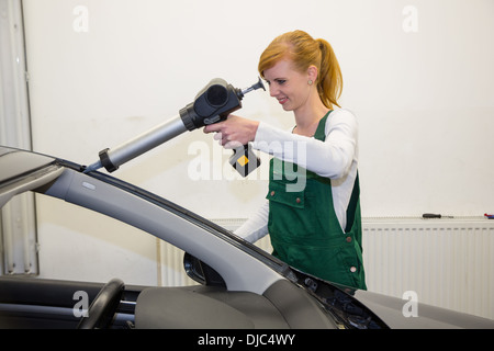 Glazier avec pistolet d'appliquer l'adhésif pour pare-brise ou le pare-brise de remplacement après stone-broyeuse Banque D'Images