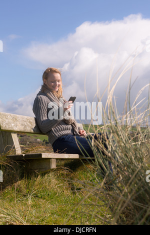 Belle femme assis sur un banc sur une journée ensoleillée Banque D'Images