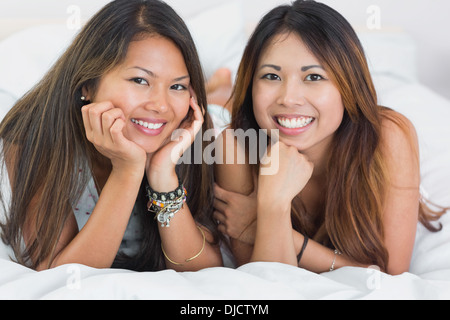 Deux belles jeunes filles sur un lit Banque D'Images