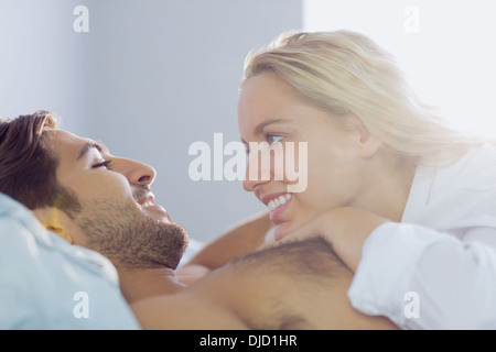 Cheerful young couple cuddling dans leur lit Banque D'Images