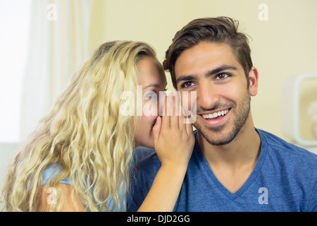 Jeune femme blonde murmurer quelque chose à son petit ami Banque D'Images