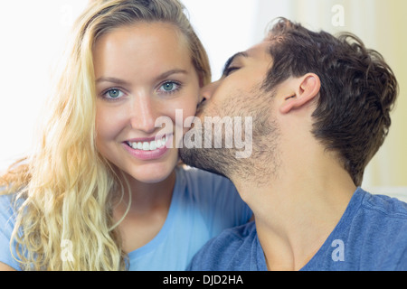Jeune femme blonde d'être embrassé sur la joue par son petit ami Banque D'Images