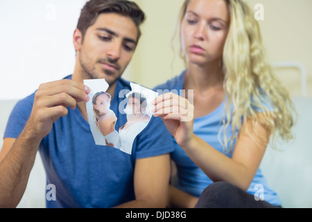 Jeune couple de déchirer une photo d'eux Banque D'Images