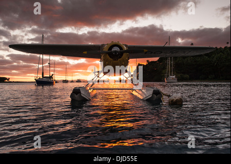 Un hydravion privé lié à un port de copra Shed bouée en face de yachts amarrés sur bouées autres au coucher du soleil. Savusavu, Fiji Banque D'Images