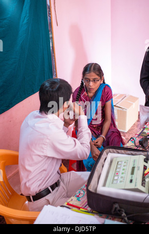 Deaf Indian village girl essayant d'une aide auditive à Sathya Sai Baba l'hôpital mobile. L'Andhra Pradesh, Inde Banque D'Images