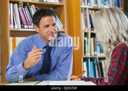 Professeur souriant expliquant quelque chose à l'étudiant blond Banque D'Images