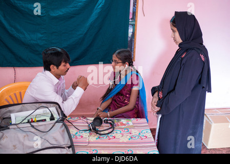 Deaf Indian village girl essayant d'une aide auditive à Sathya Sai Baba l'hôpital mobile. L'Andhra Pradesh, Inde Banque D'Images