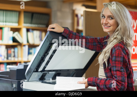 Très jolie jeune étudiant en utilisant un photocopieur Banque D'Images