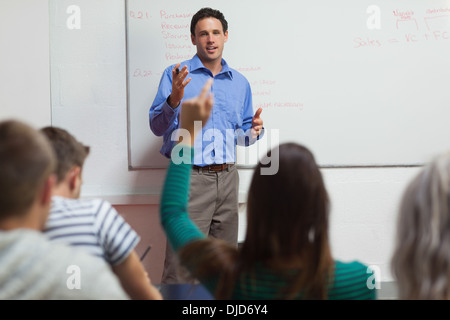 Student raising son bras et conférencier gesturing Banque D'Images