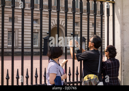 Un des touristes à la porte du palais de Buckingham, London, UK Banque D'Images