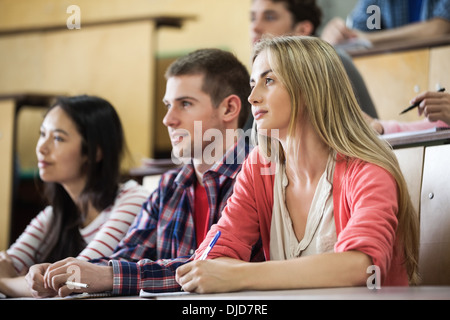 Happy students listening in lecture hall Banque D'Images