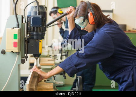 Stagiaire avec des lunettes de percer le bois Banque D'Images