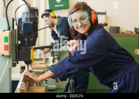 Stagiaire en souriant avec des lunettes de percer le bois Banque D'Images