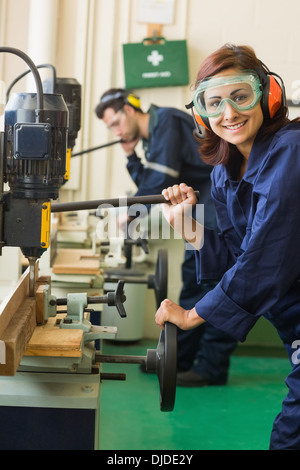 Cheerful stagiaire avec des lunettes de percer le bois Banque D'Images