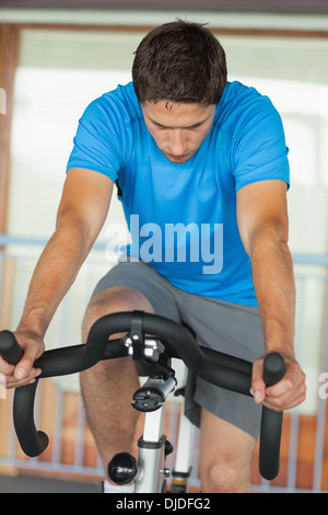 Man working out at spinning class in gym Banque D'Images