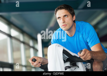 Déterminé young man working out at spinning class Banque D'Images