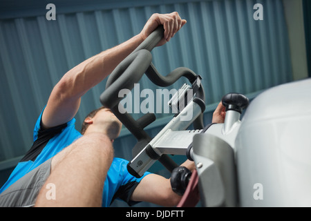 Homme déterminé working out at spinning class in gym Banque D'Images