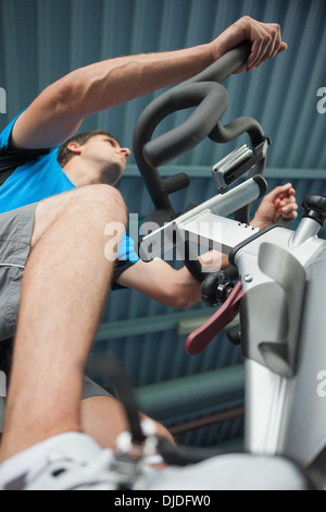 Homme déterminé working out at spinning class in gym Banque D'Images