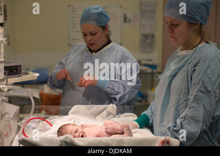 Bébé nouveau-né garçon d'être vérifié par des infirmières à l'hôpital théâtre de la maternité sur la salle de travail à l'hôpital, Kingston Upon Thames, Royaume-Uni Banque D'Images
