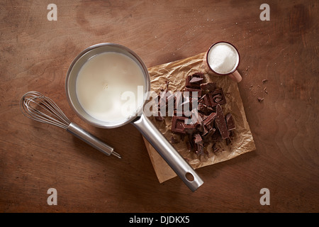 Chocolat chaud au lait ingrédients sur table en bois donnent sur shot Banque D'Images