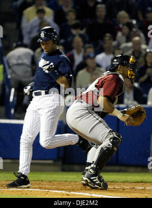 12 mars 2004, à Tampa, FL, USA ; New York Yankees' l'arrêt-court Derek Jeter traverse la plaque derrière Astros catcher Raul Chavez sur une notation Gary Sheffield base hit dans la 1ère manche dans un match d'entraînement de printemps avec les Astros de Houston à Legends Field à Tampa, Floride, le vendredi 12 mars, 2004. Yankees défait les Astros 2-1. Banque D'Images