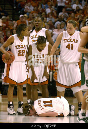 Mar 23, 2004 ; Austin, TX, USA ; Texas guard JAMIE CAREY jette sur le plancher comme coéquipiers NINA NORMAN (22), COCO REED (23), STACY STEPHENS (41) et TIFFANY JACKSON (retour) stand sur elle après qu'elle s'écrasa dans un lecteur de l'État du Michigan, distributeur auxiliaire un écran lors de second tour de l'équipe féminine de basket-ball de NCAA Tournament à Austin, le mardi 23 mars 2004. Banque D'Images