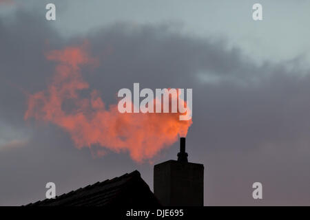 Wiesentheid, Allemagne. 26 nov., 2013. La fumée d'une cheminée est illuminée par le soleil du soir rouge à Wiesentheid, Allemagne, 26 novembre 2013. Photo : Daniel Karmann/dpa/Alamy Live News Banque D'Images