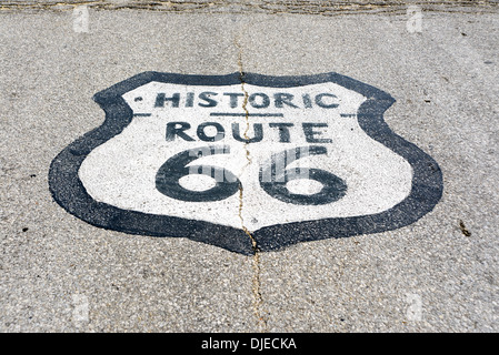 Photo ensoleillée de l'historique Route 66 road sign peints sur une route goudronnée sur le tronçon de la Route 66 entre Chicago, Illinois et St Louis, Missouri Banque D'Images