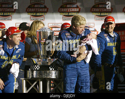 Nov 19, 2004 ; Homestead, FL, USA ; BOBBY HAMILTON, vainqueur de la NASCAR Craftsman Truck Series 2004 fixe dans les yeux de sa petite-fille Haylie lors de cérémonie de remise des prix en piste à Homestead-Miami Speedway. Banque D'Images