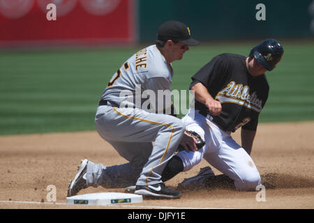 27 juin 2010 - Oakland, Californie, États-Unis - 27 juin 2010 : Oakland Athletics SS Cliff Pennington (2) glisse en troisième base comme la balle est par Pittsburgh Pirates si Andy LaRoche (15) au cours de la MLB Interleague match entre les Athletics d'Oakland et les Pirates de Pittsburgh au Oakland-Alameda County Coliseum à Oakland, CA. La visite de pirates est tombé à l'Athlétisme 3-2. (Crédit de droit Banque D'Images