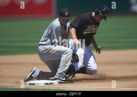 27 juin 2010 - Oakland, Californie, États-Unis - 27 juin 2010 : Oakland Athletics SS Cliff Pennington (2) glisse en troisième base comme la balle est par Pittsburgh Pirates si Andy LaRoche (15) au cours de la MLB Interleague match entre les Athletics d'Oakland et les Pirates de Pittsburgh au Oakland-Alameda County Coliseum à Oakland, CA. La visite de pirates est tombé à l'Athlétisme 3-2. (Crédit de droit Banque D'Images